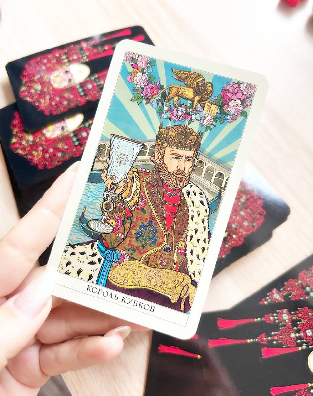 Крупный план карты «Король кубков» из Венецианского Таро в руке: королевская одежда, водные символы и авторская стилизация художницы.