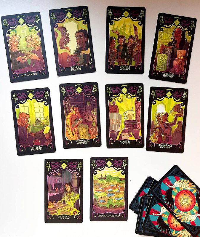 Фотография рядов карт таро: видно изображения, ассоциирующиеся с мастью Людей, сцены быта и взаимодействий в тёплых тонах.