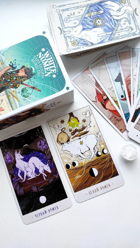 Крупный план нескольких карт колоды «Таро Белого Божества»: иллюстрации духов-животных, фазы луны и насыщенные цветовые решения.