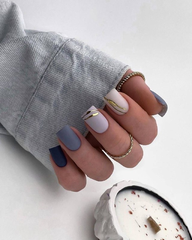 Рука с пастельно-голубым и нюдовым маникюром, тонкие золотые элементы и кольца, текстильный фон, аккуратный стайлинг рук.