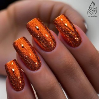 Яркие оранжево‑бронзовые ногти с сильным глиттерным эффектом и мелкими блёстками, визуально насыщенные и праздничные.