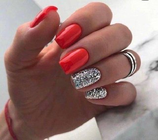 Короткие квадратные ногти с насыщенным красным покрытием и акцентным ногтем, полностью усыпанным серебристым глиттером для контраста.