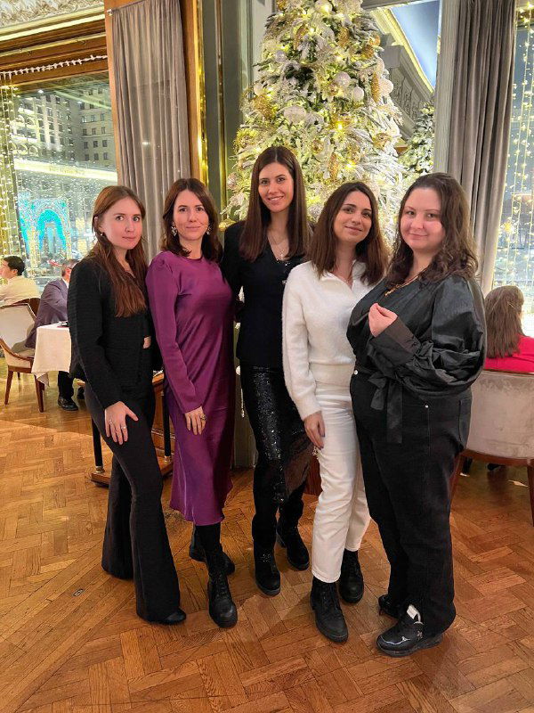 Группа из пяти женщин у нарядной новогодней ёлки в ресторане; дружеская фотография в праздничной обстановке, автор среди подруг.