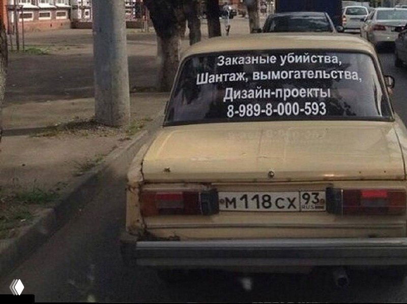 Фотография машины с надписью-рекламой на заднем стекле о подозрительных услугах — уличный снимок с чёрным юмором и провокационной надписью.