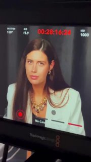 Монитор видеокамеры показывает крупным планом лицо автора во время записи подкаста о книге «Психология в Таро», студийный кадр.