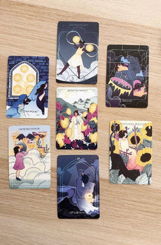 Фотография девяти карт Таро, выложенных в сетку на столе; заметны яркие элементы, подсолнухи на иллюстрациях и тёмные фоны.