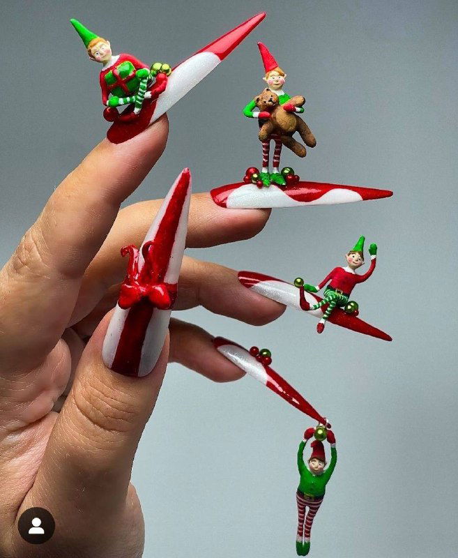 Длинные красно‑белые ногти с миниатюрными фигурками эльфов и праздничными деталями, насыщенный сценический дизайн для тематической вечеринки.