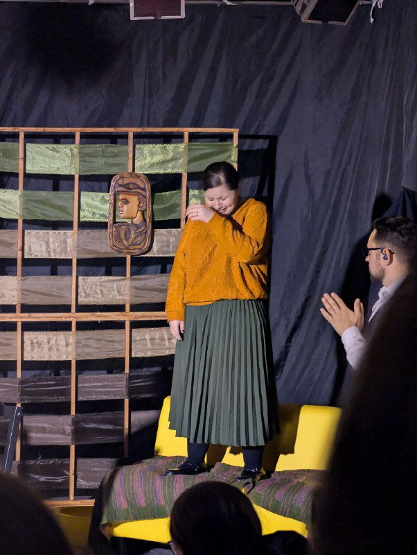 Актриса выходит на сцену, эмоция и живой контакт с публикой заметны в кадре — ощущение близости малого зала.