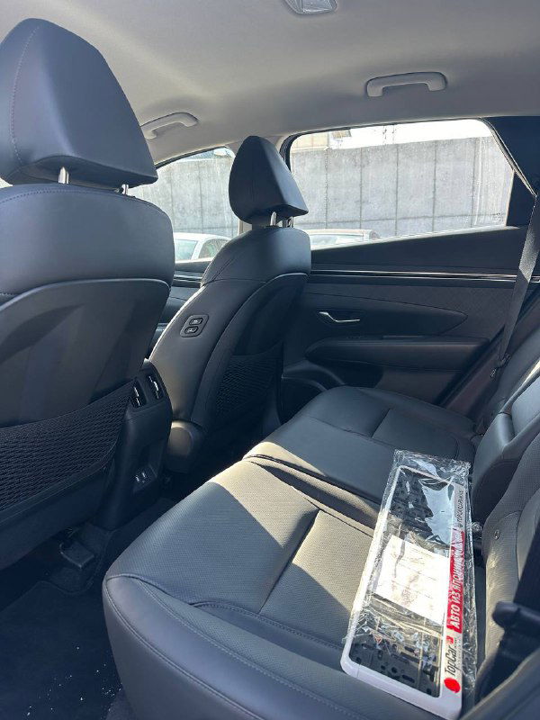 Задний ряд сидений Hyundai Tucson: видны подголовники, пространство для ног и состояние обивки, демонстрирующие комфорт для пассажиров и сохранность салона перед отправкой.