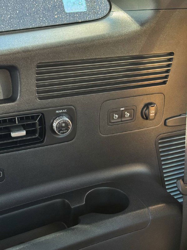 Крупный план задней панели и элементов управления багажного отделения KIA Sorento, видно розетки и крепления, обивка в тёмных тонах.