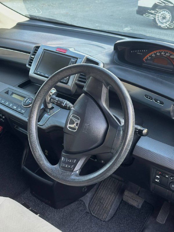Интерьер: вид на руль и панель приборов Honda Freed, кожа руля, расположение приборов и общий вид водительской зоны для оценки состояния.