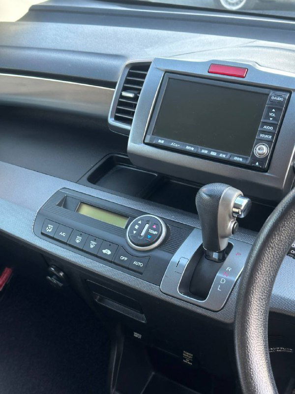 Центральная консоль и мультимедийный экран Honda Freed, селектор коробки передач и блок управления климатом — фото для проверки оборудования.