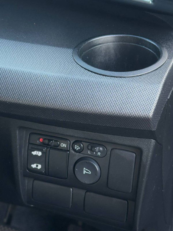 Блок управления боковыми зеркалами и дополнительных функций на панели Honda Freed — близкий план управляющих клавиш и состояния пластика.