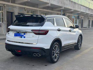 Geely Coolray белого цвета — вид сзади и правого бока на парковке; заметны задние фонари, выхлопные патрубки и состояние кузова без окрасов