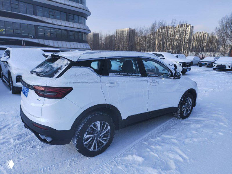 Geely Coolray 2021 — боковой ракурс автомобиля на снежной площадке, видны колёса, линия крыши и состояние задней части для оценки внешнего вида.