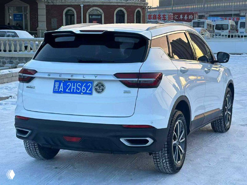 Задняя часть белого Geely Coolray 2021 на заснеженной парковке; видны фонари, бампер и пропорции кроссовера, чистый кузов без повреждений.