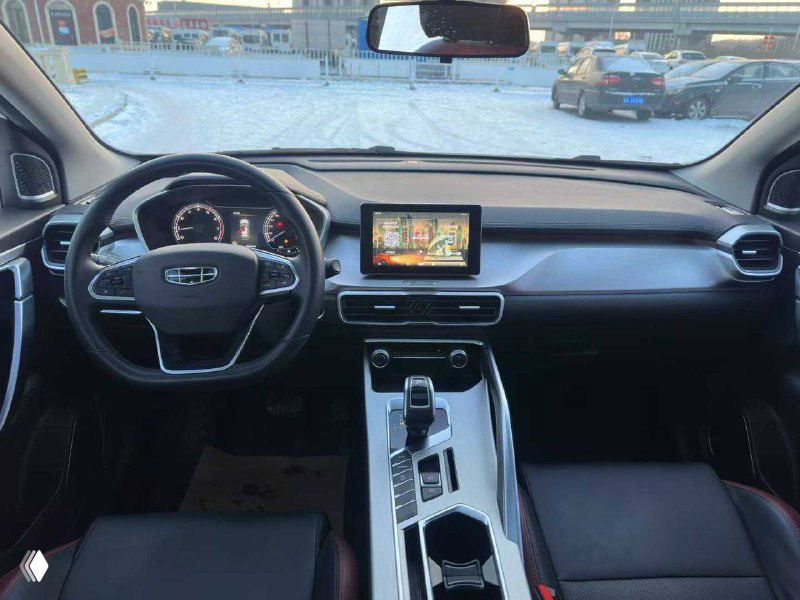 Панель приборов и центральная консоль Geely Coolray 2021: дисплей мультимедиа, руль, селектор коробки и элементы управления на фоне зимней стоянки.