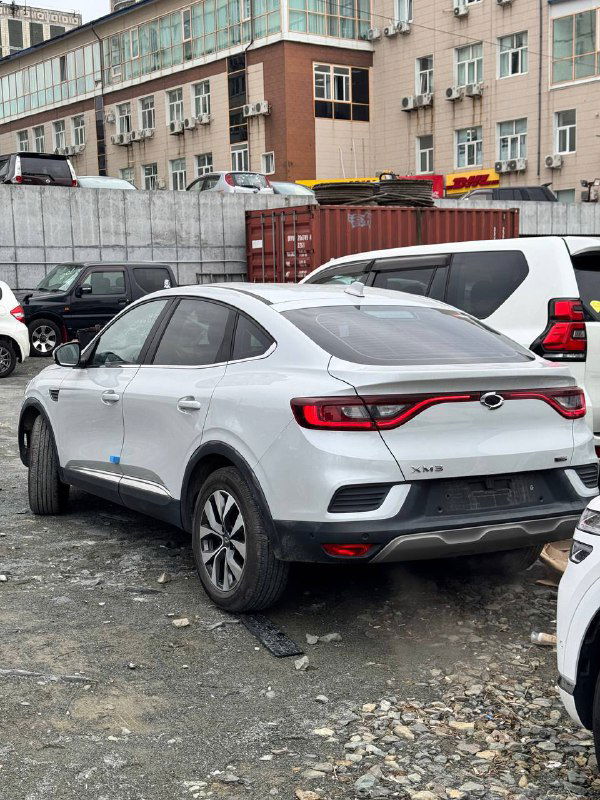 Задняя часть серебристого Samsung XM3 2020 — профиль купе‑кроссовера, видна светодиодная оптика, бампер и общий контекст парковки.