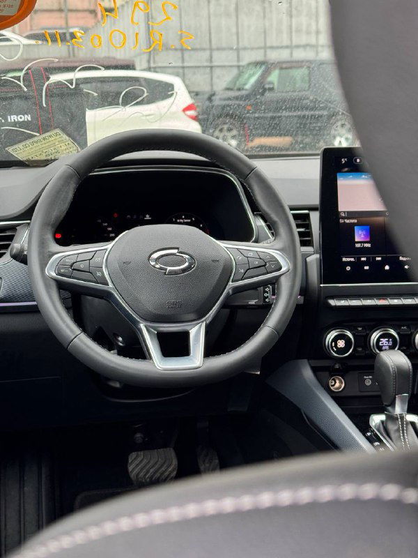 Руль и цифровая панель Samsung XM3: крупный план салона, видны мультируль, дисплей приборов и часть переднего сиденья в кожаной отделке.