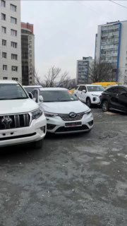 Парковка автомобилей: в кадре несколько машин включая Samsung XM3 и Toyota Prado, изображение показывает общий контекст стоянки продавца.