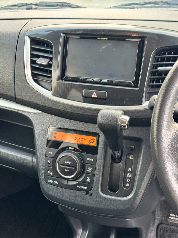 Центральная консоль и медиасистема Suzuki Wagon R: дисплей магнитолы, рычаг автоматической коробки передач и климат-контроль.