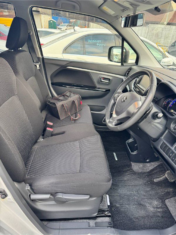 Передние сиденья и часть салона Suzuki Wagon R: тканевая обивка, пассажирское место и обзор дверей изнутри.