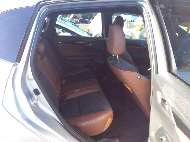 Задний ряд сидений Honda Fit 2018: открытая дверь, видны места для пассажиров, состояние задних кресел и пространство для ног.