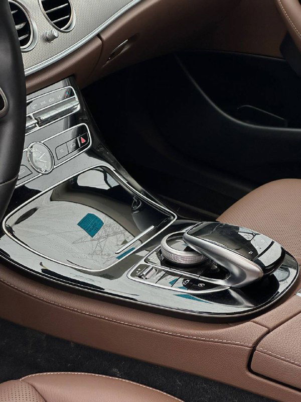 Средняя консоль Mercedes E350 с селектором передач, сенсорной панелью и блестящими поверхностями — отражения и элементы управления видны крупно.