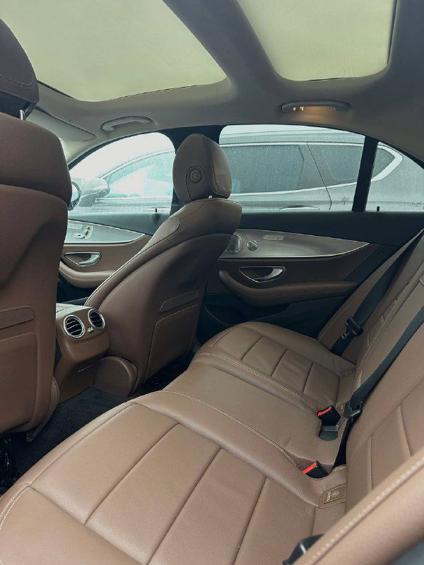 Задний ряд сидений Mercedes E350: пространство для пассажиров, подголовники, панорамная крыша и общий вид интерьера снаружи задней двери.