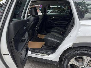 Задние двери и пассажирский ряд Hyundai Santa Fe: вид на кожаные задние сиденья, подголовники и пространство для ног, фотография сделана с улицы.