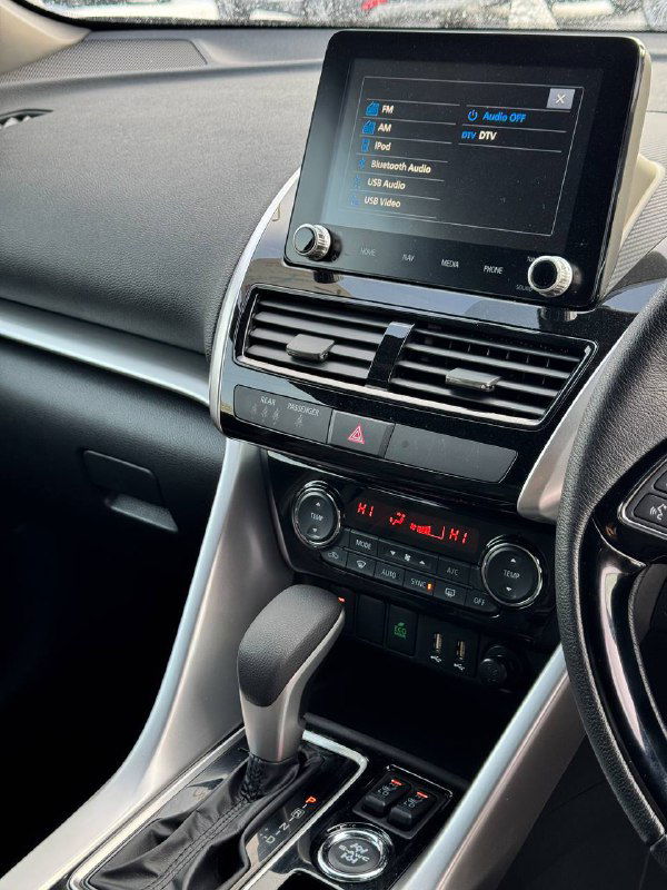 Центральная консоль Mitsubishi Eclipse Cross 2023 с экраном мультимедиа, селектором коробки и климат-контролем; фото демонстрирует оснащение и состояние панели.