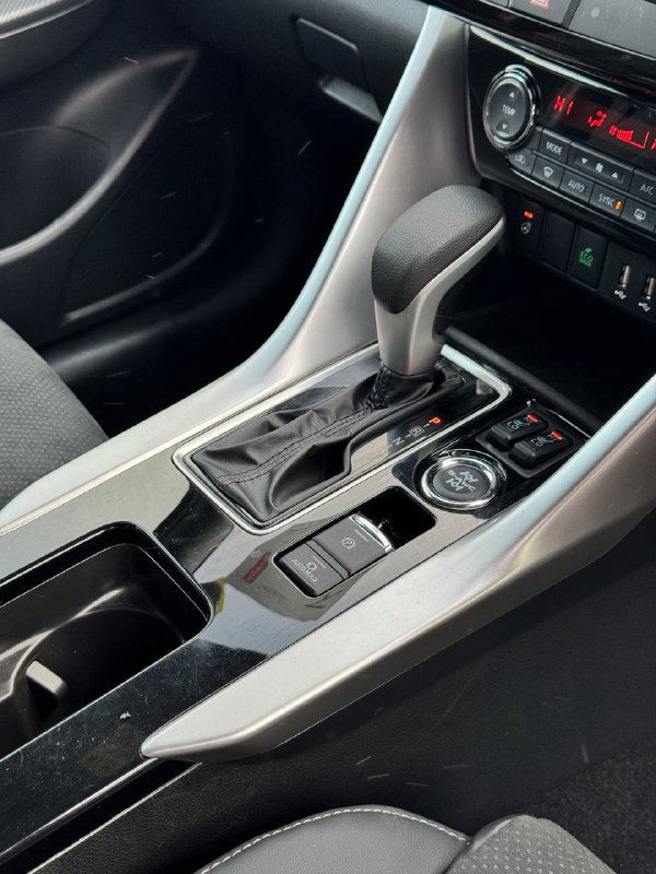 Крупный план селектора передач и центральной области салона Mitsubishi Eclipse Cross 2023; показывает наличие кнопок режимов и декоративных вставок.