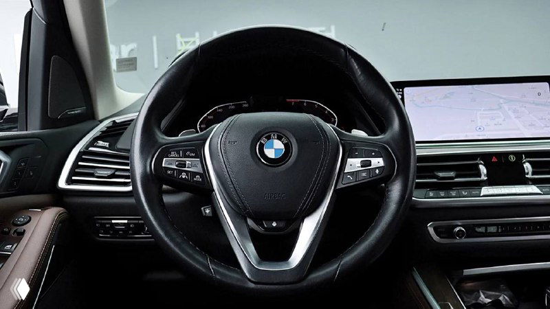 Салон — вид на руль и торпедо BMW X5, черная отделка, мультируль, экран мультимедиа, общий вид передней панели.