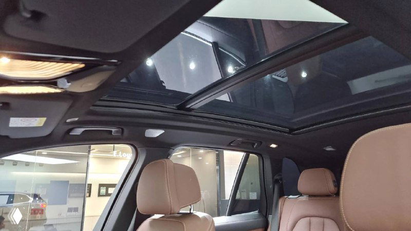 Вид на салон с панорамным люком и передними сиденьями BMW X5, освещённый интерьер, демонстрация озвученных опций.