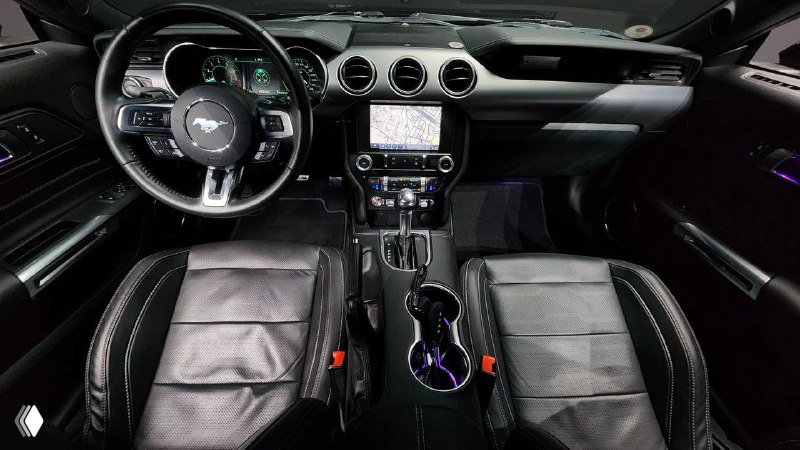 Салон Ford Mustang Coupe 2021 — вид на рулевую колонку, центральную консоль и сиденья, чёрная кожа и мультимедийный экран в кадре.
