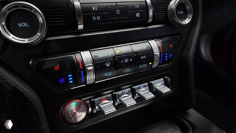 Блок климат-контроля и переключатели в салоне Ford Mustang Coupe 2021 — декоративные элементы, хромированные ручки и подсветка управления климатом.