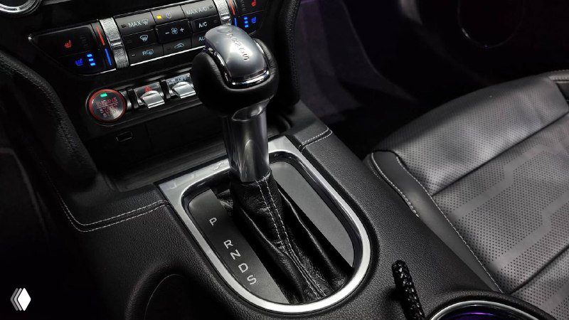 Рычаг коробки передач Ford Mustang Coupe 2021 — автоматическая трансмиссия, декоративная окантовка и область подстаканников рядом с селектором.