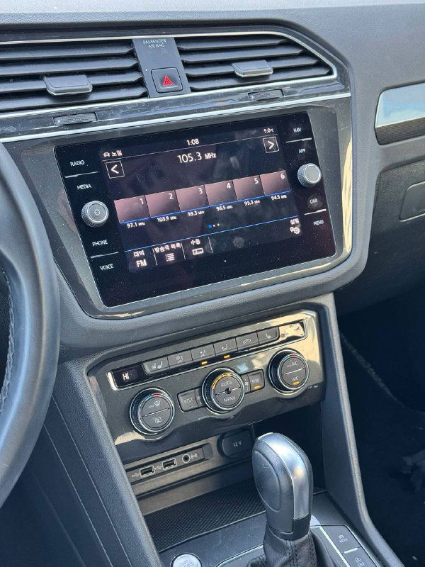 Мультимедийная панель и центральная консоль Volkswagen Tiguan 2020 — экран, кнопки и элементы управления климатом крупным планом.