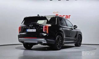 Задний ракурс черного Hyundai Palisade рестайлинг 2022 в помещении дилера, вид на багажник и задние фонари автомобиля.