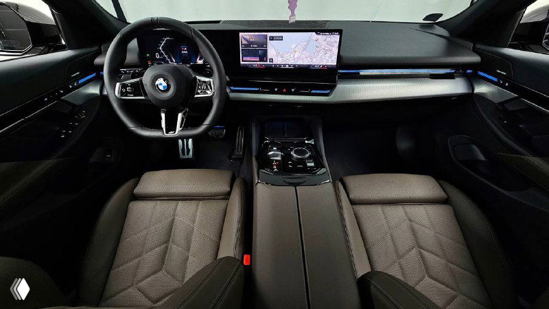 Фото салона тёмного BMW 520i M Sport — крупный план центральной консоли и сидений, декоративная подсветка и мультимедийный экран видны чётко.