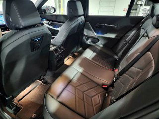 Фото задних сидений BMW 523d M Sport — тёмная кожаная обшивка, пространство для ног, ремни безопасности и общий вид заднего ряда.