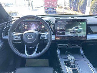 Панель приборов и большой центральный сенсорный экран GAC Trumpchi GS8 — видно рулевое колесо, индикаторы и медиасистему в салоне автомобиля.