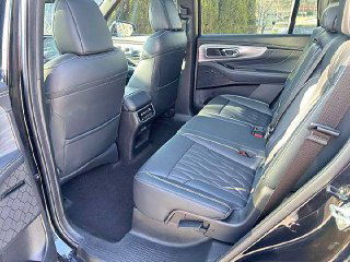 Задний ряд семиместного GAC Trumpchi GS8 — пространство для пассажиров, кожаные кресла и задний подлокотник, иллюстрирующие комфорт для пассажиров второго ряда.