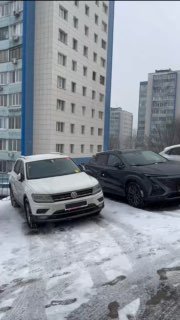 Стоянка с несколькими автомобилями (внедорожники и кроссоверы) на снегу у жилых домов — авто, ожидающие отправки и продажи.