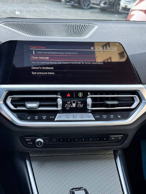 Центральная консоль и мультимедиа дисплей BMW 320i 2021 M‑Sport — экран, дефлекторы и элементы управления климатом, вид салона спереди.