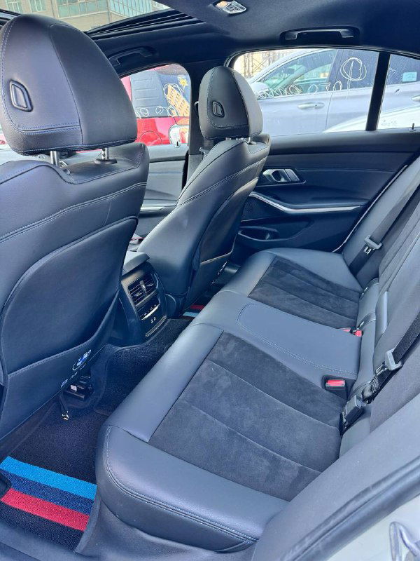 Задний ряд сидений BMW 320i 2021 M‑Sport — вид на пространство для пассажиров, состояние обивки и посадочных мест, общий ракурс салона сзади.