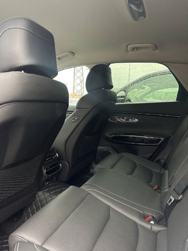 Задний ряд сидений Genesis GV70: обивка, пространство для ног, подголовники и вентиляционные решётки — вид со стороны двери.