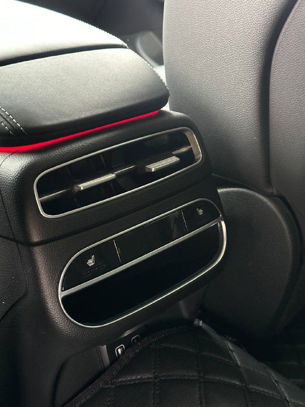 Воздуховоды и элементы управления климата для задних пассажиров в Genesis GV70: кнопки, розетки и отделка — крупный план.