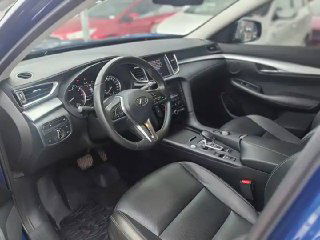 Водительская зона Infiniti QX50: руль, комбинация приборов и сиденье с кожаной отделкой, вид подчёркивает состояние переднего ряда и пространство.