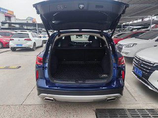 Открытый багажник Infiniti QX50 с ровной площадкой для груза, видна защитная накладка и объём моторного отсека багажа на парковке импорта.